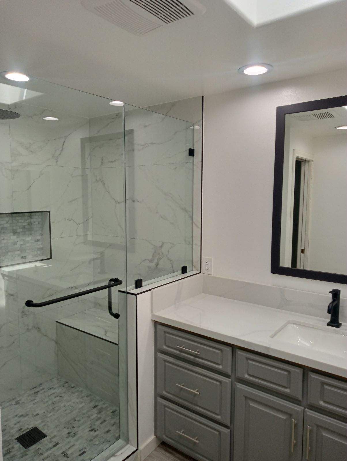 Finished Anaheim vanity with a gray cabinet, white counter, and black mirror
