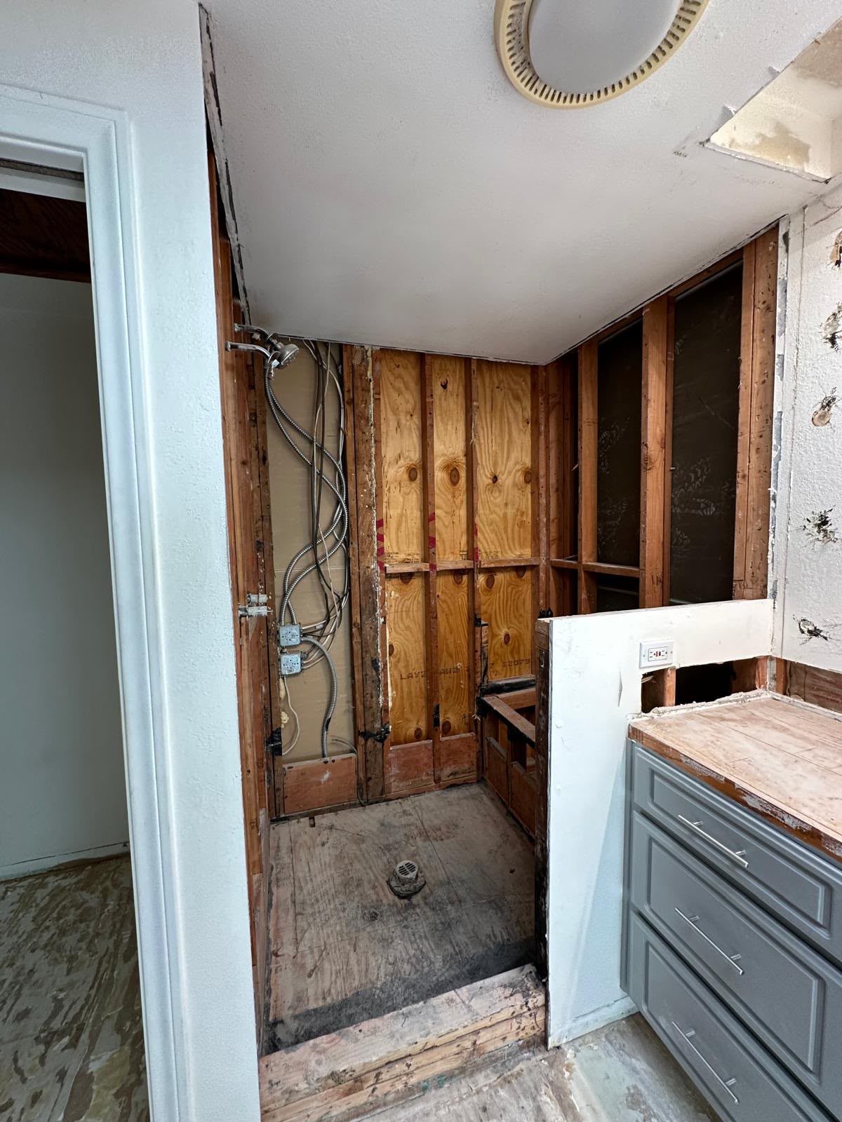 Anaheim bathroom opened to the studs, with new wiring and the shower drain in place