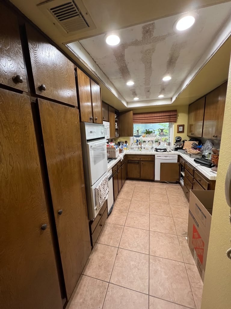 Azusa kitchen before the remodel, with dark wood cabinets and a tile floor